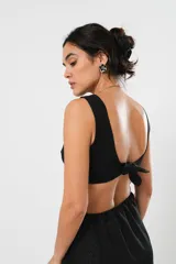 Vestido corto negro con lurex, escote en V, corte asimétrico y detalle cut-out en la cintura.