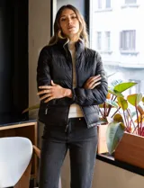 Campera puffer reversible negra, marca Michael Kors, con cierre frontal y bolsillos laterales. Incluye bolsa autoportante.