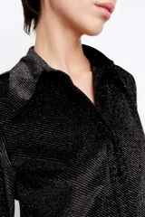 Camisa negra de punto con diseño de rayas diagonales en lurex, calce slim, cuello alargado, apertura en cartera delantera con botones negros y pinzas traseras.