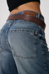 Pantalón de jean celeste de tiro medio y corte holgado. Presenta un lavado bicolor con efecto desgastado y terminación levemente fruncida en el bajo.