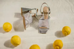 Sandalias rojas con capellada de cuero y rejilla, taco geométrico y pulsera al tobillo.