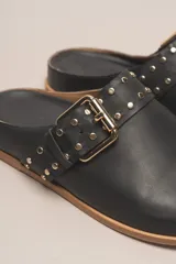 Zueco destalonado de cuero vacuno con estampado de leopardo. Presenta una tira ancha con hebilla metálica dorada sobre el empeine.