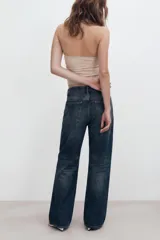 Jeans de mezclilla de tiro medio con cinco bolsillos, diseño relaxed fit de corte recto y amplio, con efecto lavado y desgaste frontal.