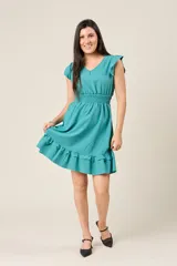 Vestido corto blanco con cuello en V, mangas cortas con volados, cintura elastizada y falda con volados.