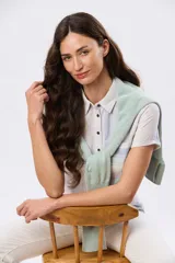 Camisa de lino de manga corta con rayas en tonos suaves, cuello camisero, cierre frontal parcial con botones y un bolsillo en el pecho.