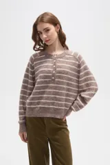 Sweater de punto a rayas horizontales en tonos marrón y blanco, con cuello redondo y cierre frontal parcial con botones. Presenta un diseño holgado de manga larga con puños y ruedo acanalados.