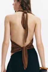 Top halter marrón de punto elástico con escote drapeado, tiras anchas para atar al cuello y ajuste en la parte posterior del bajo.