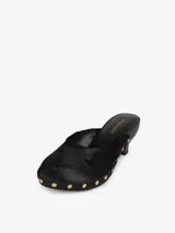 Zueco negro con capellada de pelo de becerro, base de madera con tachas doradas y tacón de cuero.
