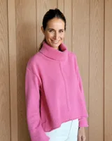 Polerón de lana lambswool color gris, con cuello alto, diseño holgado y costura central vertical. Presenta puños y ruedo acanalados con un corte ligeramente más corto en el frente.
