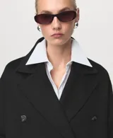 Abrigo largo de diseño oversize confeccionado en tejido mezcla de lana, con cuello de solapa con muesca, cierre frontal de doble botonadura y dos bolsillos laterales.