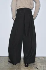 Pantalón de tiro medio confeccionado en mezcla de algodón, con diseño de corte recto y holgado. Presenta cintura con trabillas, cierre frontal con cremallera y botón, y bolsillos laterales ocultos en las costuras.