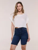Bermuda de jean azul oscuro con calce ajustado y tecnología push up. Presenta cintura con presillas, cierre frontal con botón metálico, diseño clásico de cinco bolsillos y largo por encima de la rodilla con dobladillo en el ruedo.