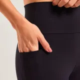 Calza deportiva de tiro alto en color negro, confeccionada en tejido elástico con bolsillo lateral integrado.