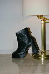 Botines negros de cuero con plataforma y tacón cuadrado.