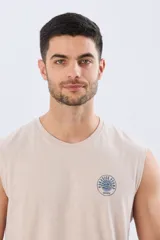 Musculosa beige jaspeado de corte clásico, con cuello redondo y diseño sin mangas. Presenta un pequeño estampado circular en el pecho con temática costera y la inscripción 'Paradise Bound'.