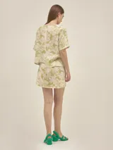 Falda corta cruzada confeccionada en mezcla de lino y viscosa, con estampado de flores y tigres en tonos verde y beige. Presenta un diseño de la marca Polonio con ajuste regulable.