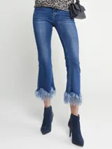 Pantalón de jean azul con corte cropped y terminación desflecada con ondas en el ruedo.