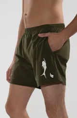 Short de baño verde oliva con cintura elástica y cordón ajustable. Presenta bordados de sirenas en las piernas y un parche con logo.