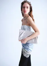 Vestido corto de tejido satinado color celeste, con diseño recto, escote recto y tirantes finos. Presenta detalles de encaje blanco en el escote y en el ruedo.