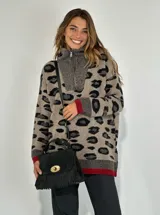 Cartera de mano negra de gamuza con flecos y cierre dorado.