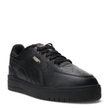 Championes urbanos Puma modelo Shuffle Downtown, de color negro con detalles en dorado. Presentan una capellada de cuero sintético con perforaciones en la puntera, cierre de cordones y suela de goma vulcanizada con tecnología SoftFoam+ para mayor amortiguación.