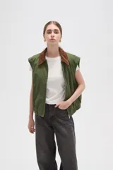 Chaleco de algodón color verde oliva, con cierre frontal y cuello de pana en color marrón. Presenta un diseño holgado con elástico en la cintura.