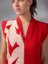 Vestido largo y recto sin mangas, confeccionado en paño de algodón con escote en V y cuello mao. Cuenta con un diseño bicolor en rojo y crudo con estampado exclusivo de hojas.