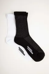 Par de medias de caña media, una blanca y otra negra con rayas plateadas.