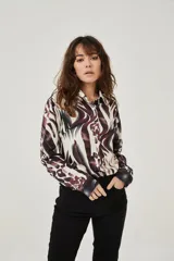 Camisa de manga larga con estampado abstracto en tonos marrones y blancos, cuello camisero y cierre frontal con botones. Puños con detalle de estampado animal print.