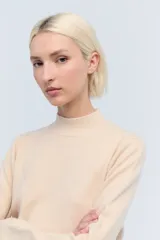 Sweater color crema de lana con cuello alto.