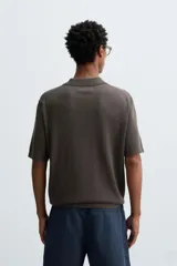 Polo de punto de corte regular fit, confeccionado en una mezcla de algodón y lyocell. Presenta cuello de solapa con cierre frontal de botones, manga corta y acabados en rib en puños y bajo.