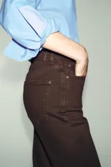Jeans de tiro alto con corte mom fit, cinco bolsillos y cierre frontal con cremallera y botón.