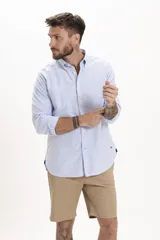 Camisa celeste de manga larga con cuello abotonado y corte clásico.