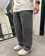Pantalón de jogging de corte holgado con efecto de lavado ácido en color gris oscuro. Presenta costuras verticales frontales y cintura elástica.