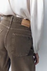 Jean de corte oxford y tiro alto, con pierna ancha desde la cadera hasta el ruedo. Confeccionado en denim rígido de color marrón, con cierre y botón frontal.
