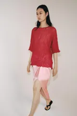 Top rojo de punto con textura efecto arrugado, cuello redondo y mangas cortas holgadas.