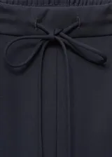 Pantalon de vestir de corte recto y tiro medio, color azul marino. Presenta cintura elástica con lazo ajustable y una raya lateral en contraste de color blanco.