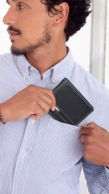 Billetera de cuero negra con costuras blancas, con compartimentos internos para billetes, tarjetas y documentos.