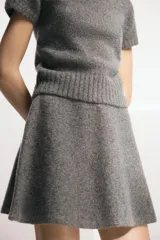 Falda corta de punto con lana, diseño acampanado en evasé y cintura elástica.