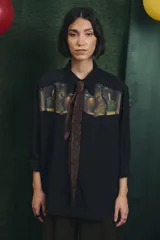 Camisa negra de manga larga con canesú frontal estampado con motivos artísticos de bodegón. Incluye una corbata fina integrada del mismo tono.