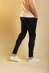 Pantalón de jean azul oscuro, corte ajustado, con cierre de botón y cremallera, y bolsillos laterales y traseros.