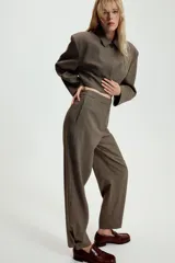 Pantalón de tiro medio con estampado de cuadros pequeños, bolsillos laterales y cierre frontal con cremallera y gancho metálico.
