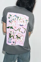 Camiseta de algodón con efecto lavado, corte oversize, cuello redondo y manga corta. Presenta estampados gráficos en el frente.