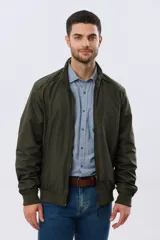 Campera liviana de nylon color azul marino, con cuello alto, cierre frontal y puños y dobladillo en elástico tejido.