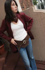 Faja de cuero marrón con diseño de bordes cosidos a mano y hebilla metálica circular. Es un accesorio versátil diseñado para ser usado tanto a la cintura como a la cadera.