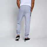 Pantalón de jogging negro con puños ajustados en los tobillos y cordón en la cintura. Presenta un escudo bordado en amarillo y negro en la pierna izquierda.