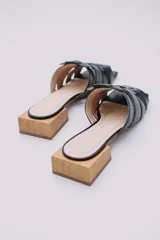 Mules de cuero celeste con diseño trenzado y taco de madera.