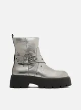 Bota corta plateada con hebilla y suela track negra.