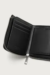 Tarjetero cuadrado de diseño minimalista en color negro, con cierre de cremallera metálica y dos ranuras internas para tarjetas.