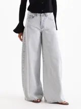 Jeans amplio de denim color celeste grisáceo, confeccionado en algodón, con tiro medio, fit holgado y efecto bombé hacia el ruedo.